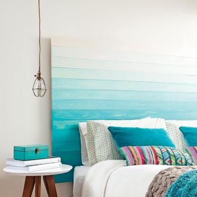 tête de lit en planches de bois teintes façon tie and dye bleu, coussins colorés bleu et bariolés, suspension baladeuse