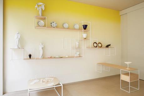 Mur jaune tie and dye dans un intérieur très contemporain, étagères de rangement très fines et graphiques